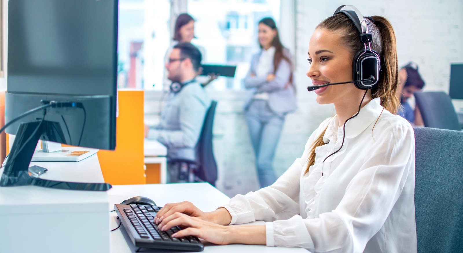 Mitarbeiterin mit Headset im Kundengespräch